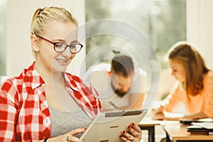 Student girl with tablet in front of her classmates