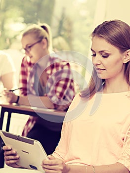 Student girl with tablet in front of her classmates