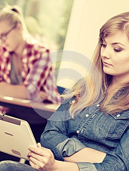 Student girl with tablet in front of her classmates