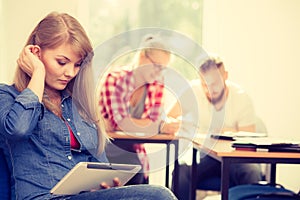 Student girl with tablet in front of her classmates