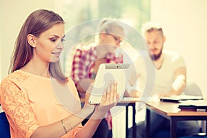 Student girl with tablet in front of her classmates