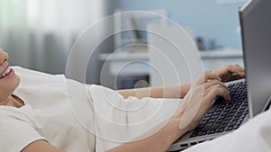 Student girl typing on laptop, communicating with friends in social network