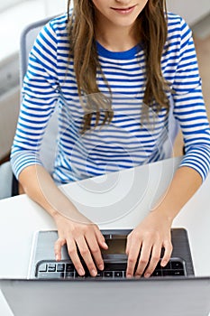 Student girl typing on laptop computer