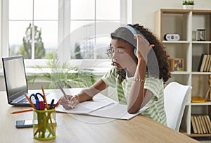 Student girl using laptop computer for online studying and doing school homework