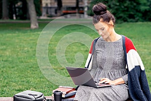 Student girl is using laptop computer in the park