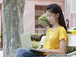 Student girl using laptop in the park