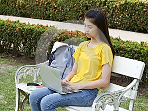 Student girl using laptop in the park