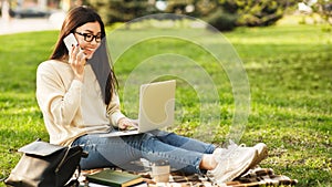 Student girl using laptop and talking on phone