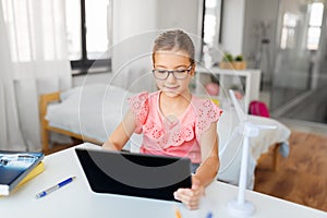 Student girl using tablet computer at home