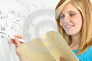 Student girl writing maths on white board