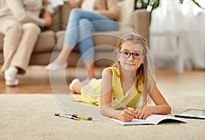 Student girl writing to notebook at home