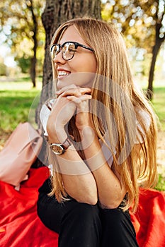 Student with glasses, resting after class in the Park sitting on