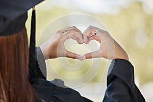 Student graduation, heart hand sign and education achievement outdoor with blurred background. University, college