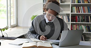 Student guy doing exercise, prepare essay, makes assignment using laptop