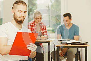 Student guy in front of her mates in classroom