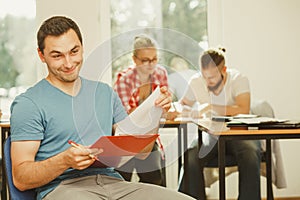 Student guy in front of her mates in classroom