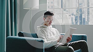 Student guy in white hoodie writes home assignment on tablet