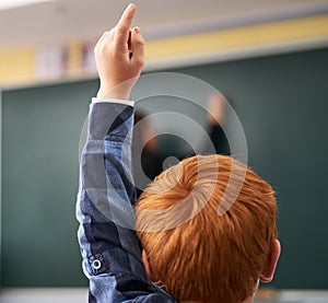 Student, hand and child in classroom with question for teacher, education and learning with school blackboard. Boy