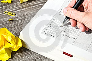 Student hand with pencil for the exam. printed school test, home education