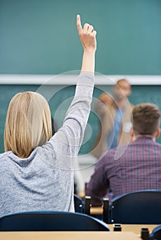 Student, hand up and question teacher at lecture for learning development or university, scholarship or behind. Person