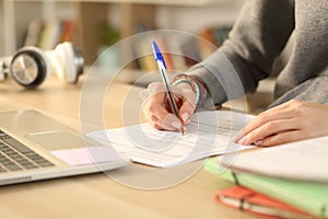 Student hands filling out form document at home photo