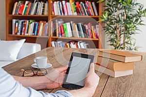 Student hands holding an ebook reader at home