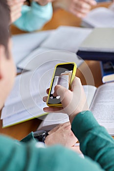 Student hands with smartphone making cheat sheet