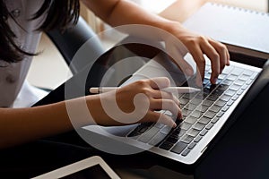 Student hands typing on laptop computer. Online working, e learning or telework concept.