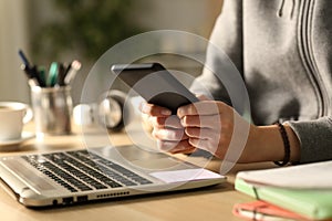 Student hands typing on smart phone at night