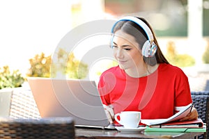 Student with headphones e-learning with a laptop