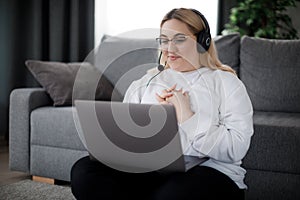 Student in headset using laptop