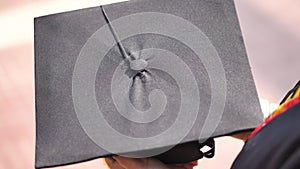 Student hold hats in hand during commencement success on yellow background