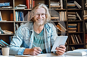 Student hold modern tablet make notes in notebook empty smile at camera