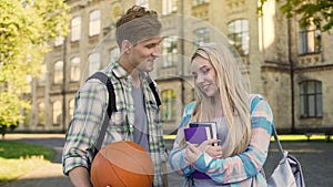 Student holding ball, flirting with pretty girl near university, asking for date