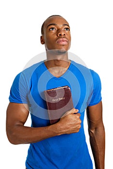 Student holding a bible looking up