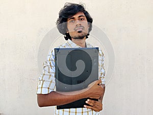 student holding closed laptop in hands. Going to attend online class