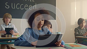 Student holding digital tablet in classroom. Schoolgirl using tablet computer