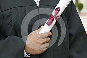 Student Holding Diploma On Graduation Day