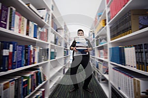 Student holding lot of books in school library