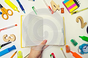 The student is holding a yellow notebook in his hands. stationery. school desk. accessories. school concept. White background. sti