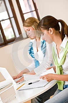 Student at home - two woman with book and laptop