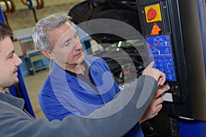 Student with instructor repairing car during apprenticeship