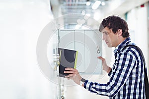 Student keeping his book in the locker