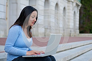 Student with laptop on campus stair