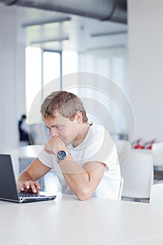 Student with laptop computer in library