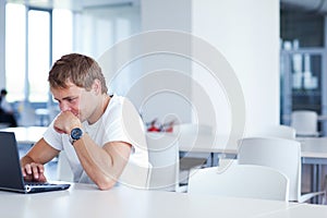 Student with laptop computer in library