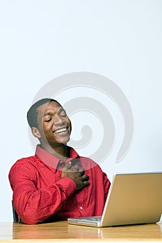Student Laughing at Laptop - Vertical