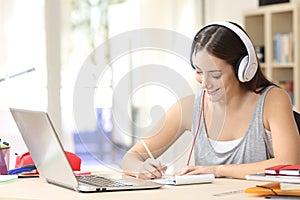 Student learning with headphones taking notes