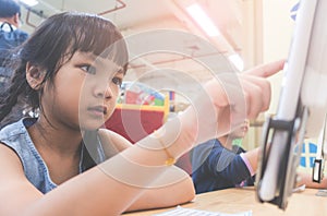 Student learning how to use tablet in classroom