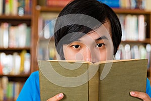 Student in library reading book photo